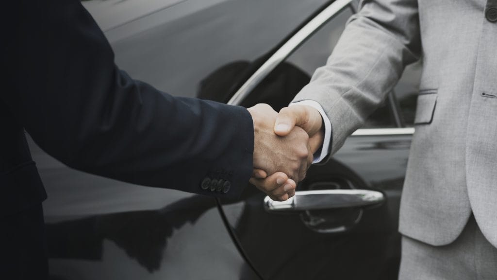 M&A process shown s a close-up of a person shaking hands with another person symbolizing a closed deal which has been made