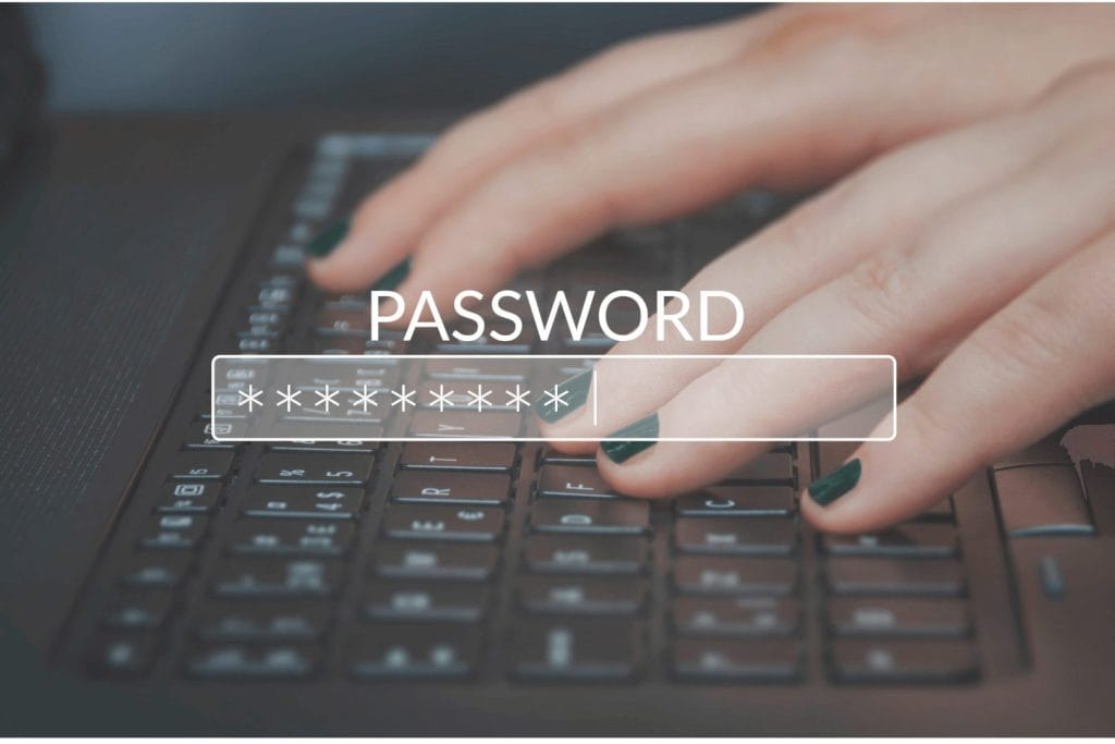 Ruke na tastaturi dok se unosi lozinka sa skrivenim znakovima prikazanim u polju za unos. 