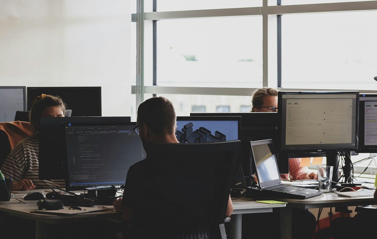 Image of a professional team working together on a business project, with a focus on a computer screen displaying financial data.