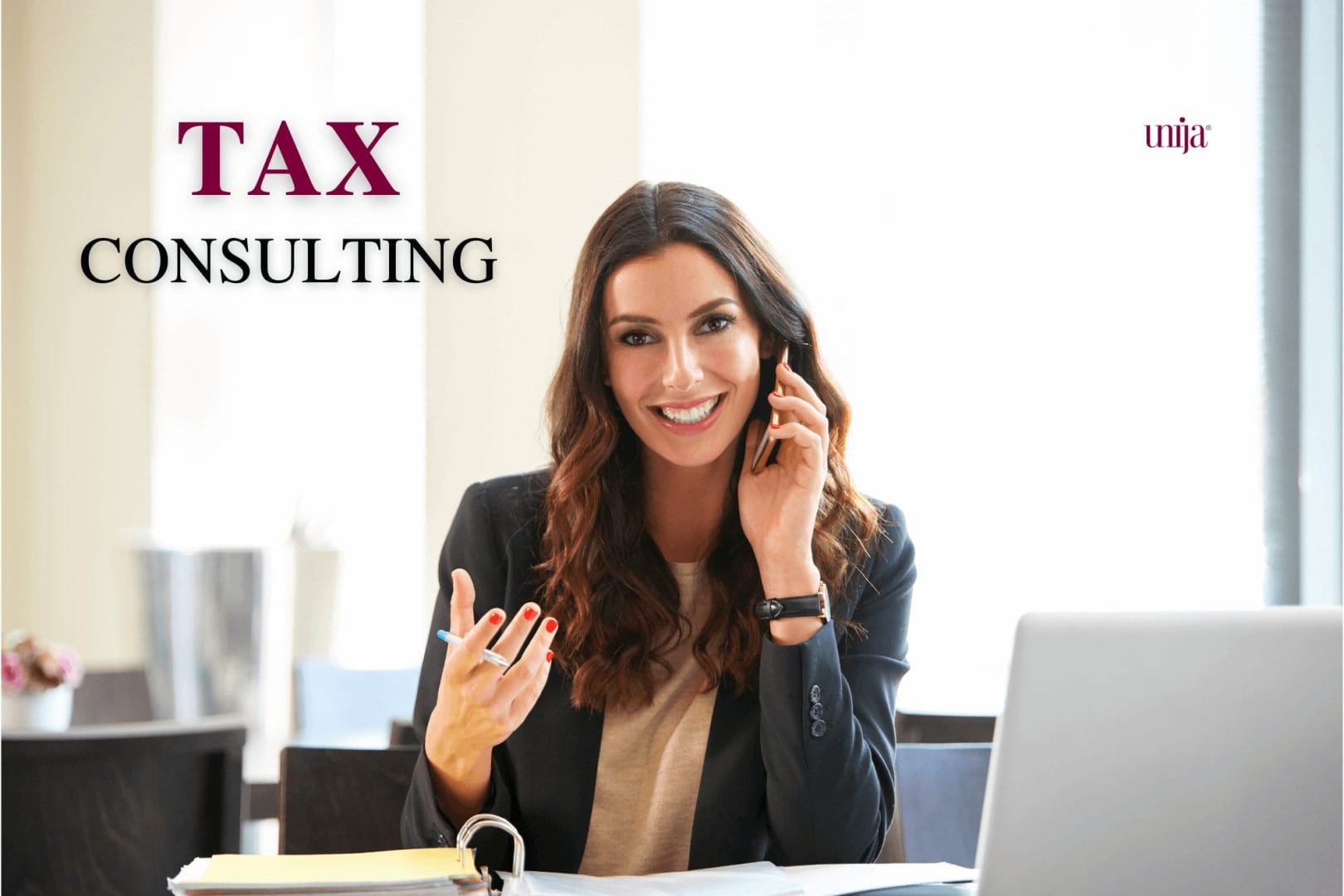A woman in a business setting talking on the phone, smiling, with a folder and laptop in front of her, with the text 'Tax Consulting' in the top left corner.