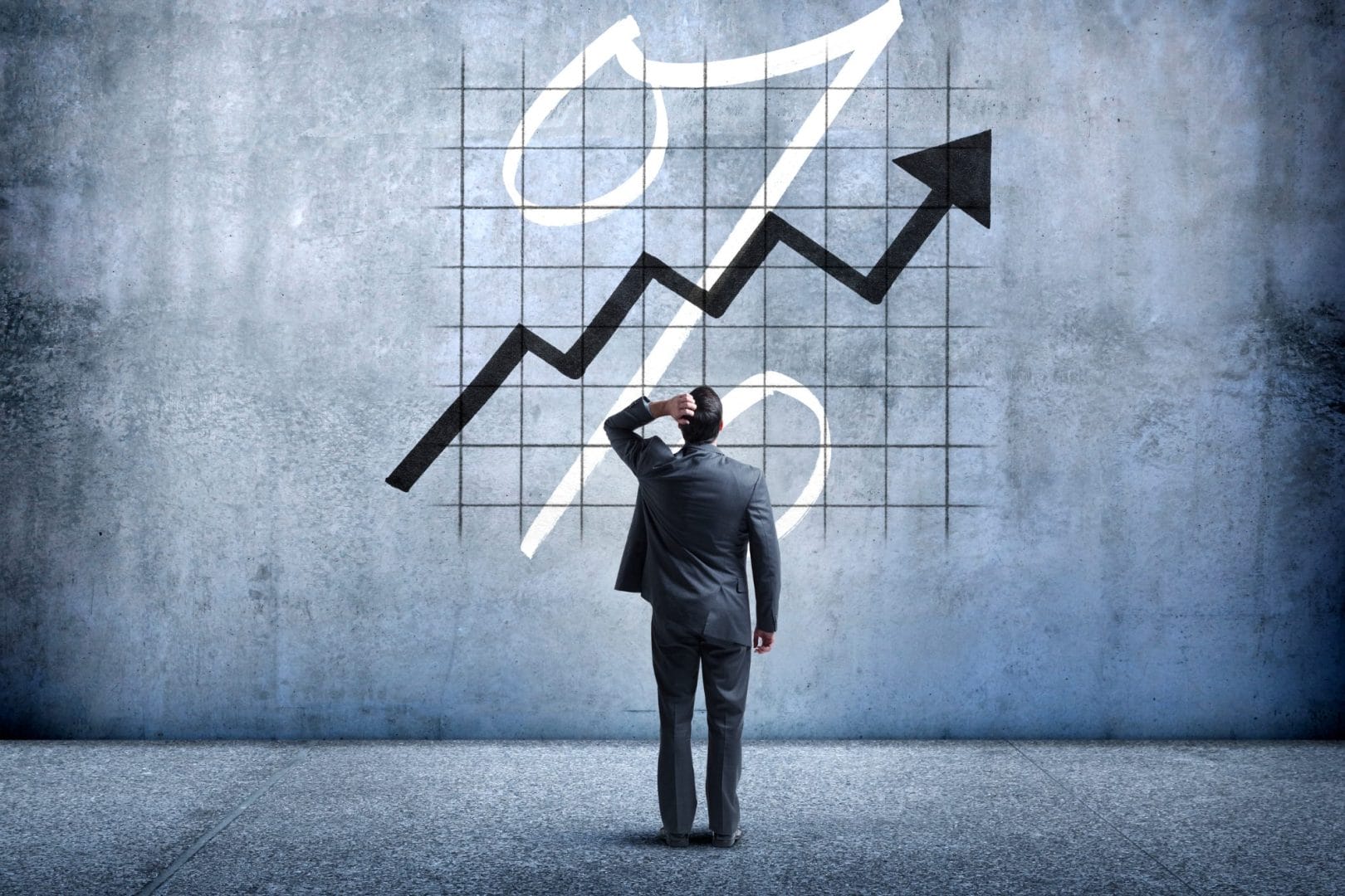 Čovek u odelu gleda grafikon sa rastućim procentima, simbolizujući kamatne stope za 2025. godinu i njihov uticaj na finansije.