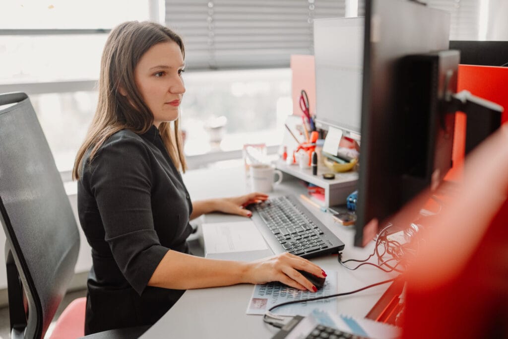 Računovođa za obračun zarada u Srbiji radi za kompjuterom u kancelariji.