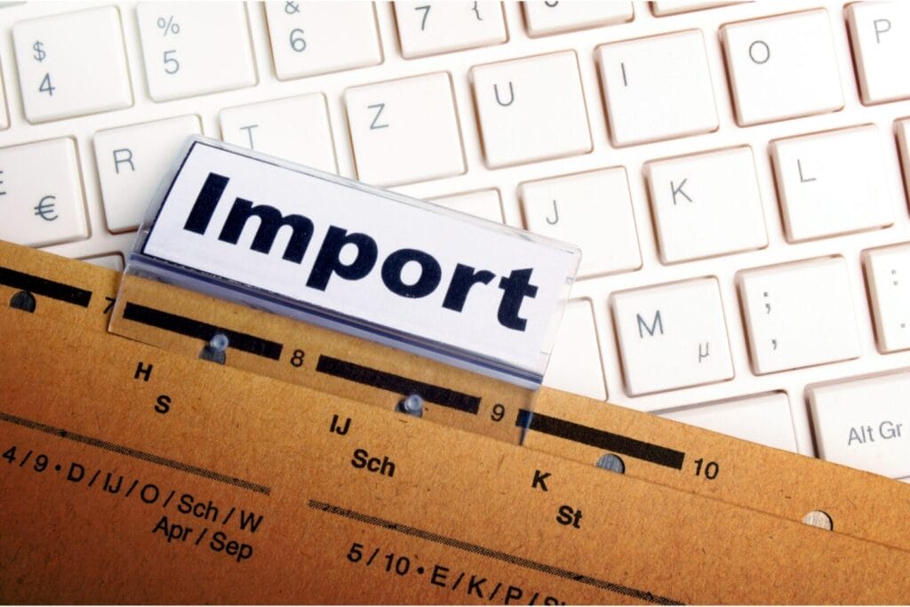 Fascikla sa oznakom “Import” na radnom stolu iznad tastature – simbol evidencije uvoza robe i E-KUF sistema za PDV.