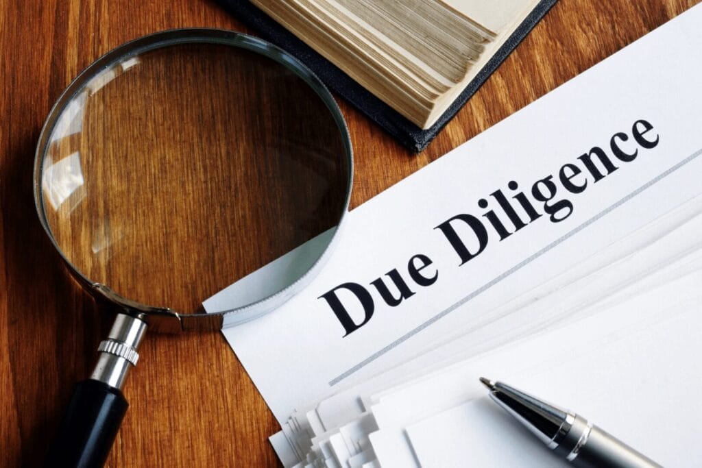 Документација за due diligence со лупа, како симбол на детална проверка на компанија