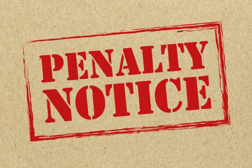 Crven pečat so natpis "Penalty notice" što simbolizira kazna ili prekršok povrzan so regres za godišen odmor.